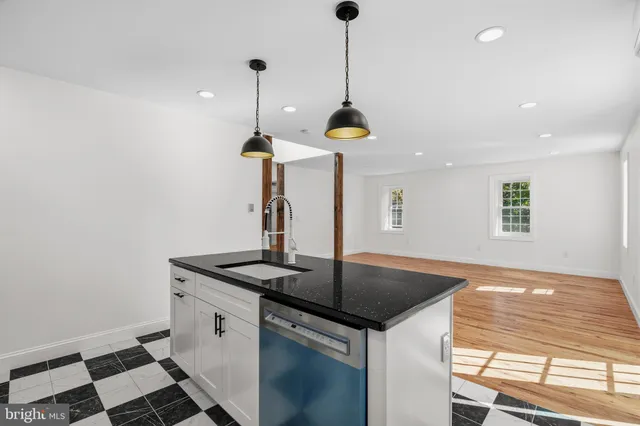 a kitchen with stainless steel appliances granite countertop a sink a stove and a window