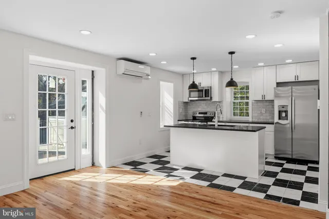 a kitchen with stainless steel appliances kitchen island granite countertop a refrigerator and a sink