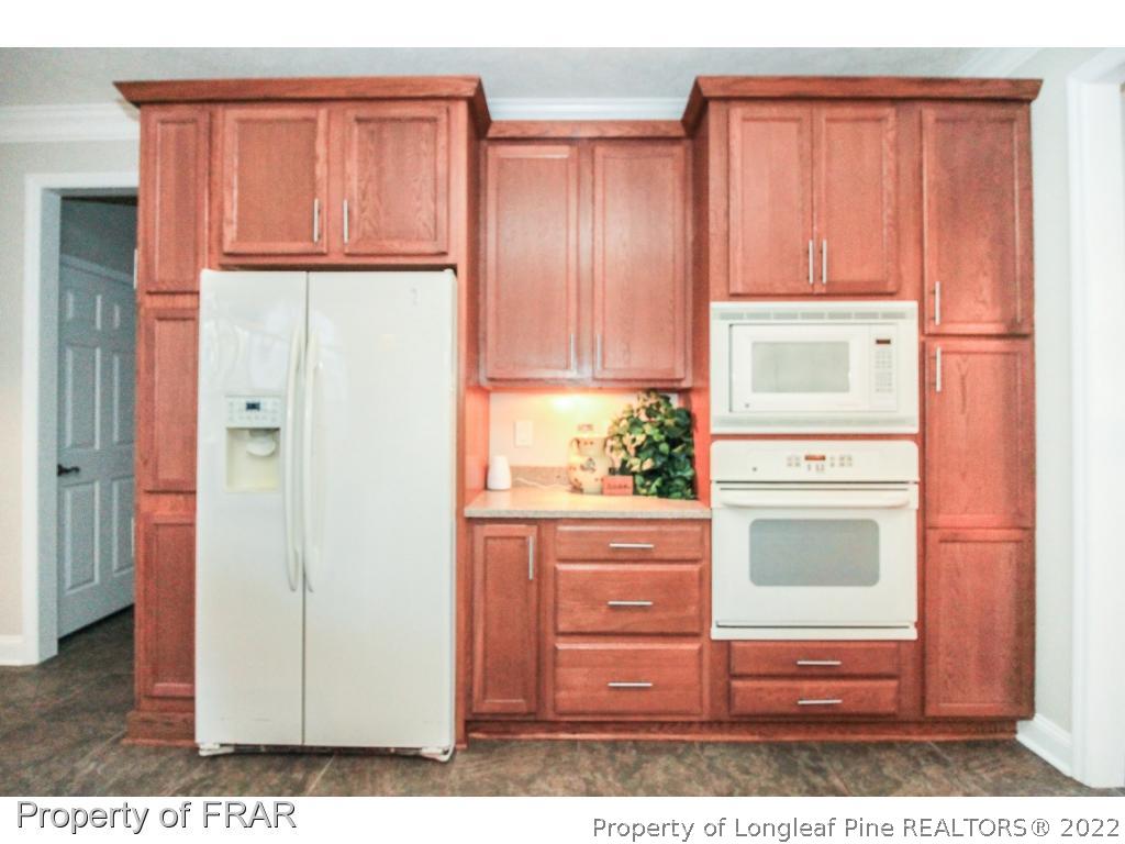 384 Booth Pond Road Raeford, NC 28376 - Photo 11 of 35 a kitchen with granite countertop wooden cabinets and a stove top oven