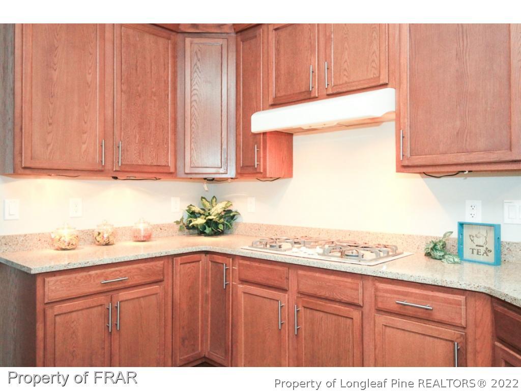 384 Booth Pond Road Raeford, NC 28376 - Photo 12 of 35 a kitchen with granite countertop wooden cabinets and sink