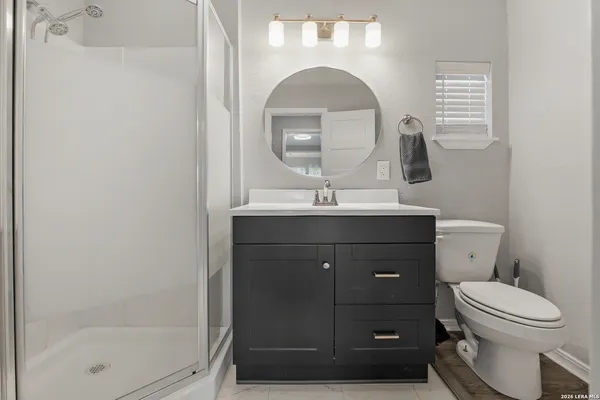 a bathroom with a toilet a sink and mirror