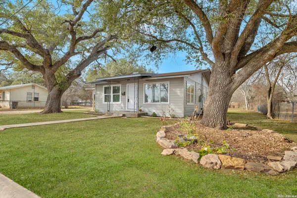 a front view of a house with a garden and trees
