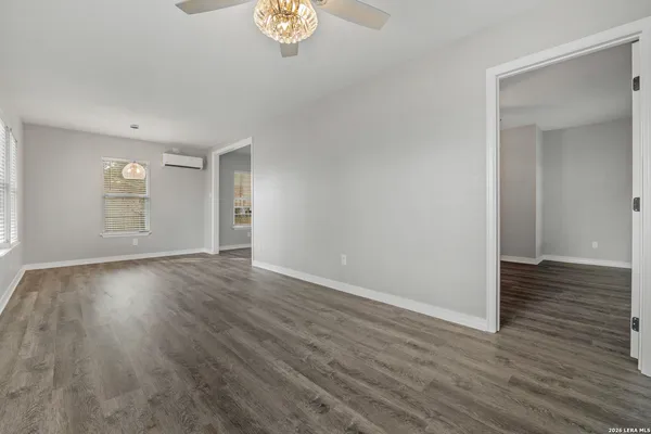 an empty room with wooden floor and windows