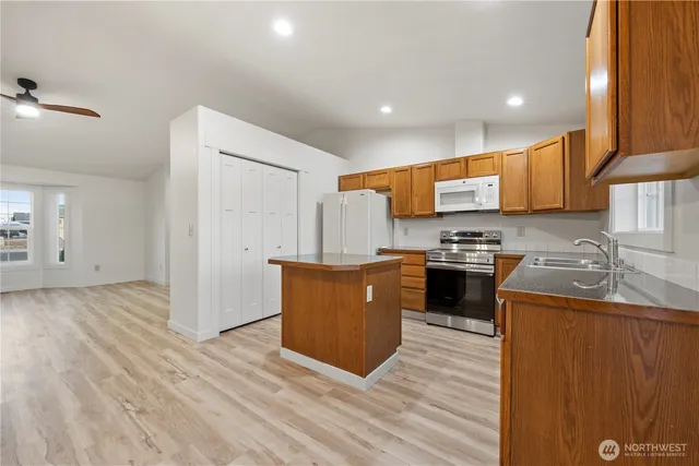 a kitchen with stainless steel appliances granite countertop a stove a sink and a refrigerator
