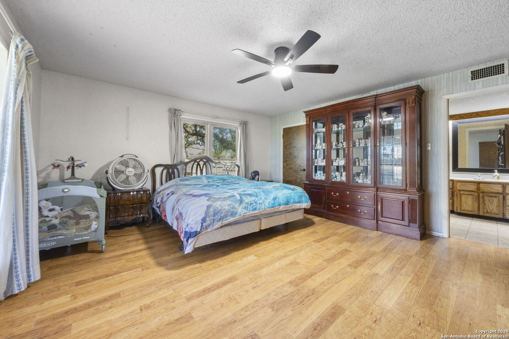 2452 2nd Street Pleasanton, TX 78064 - Photo 12 of 15 a bedroom with a large bed and a chandelier