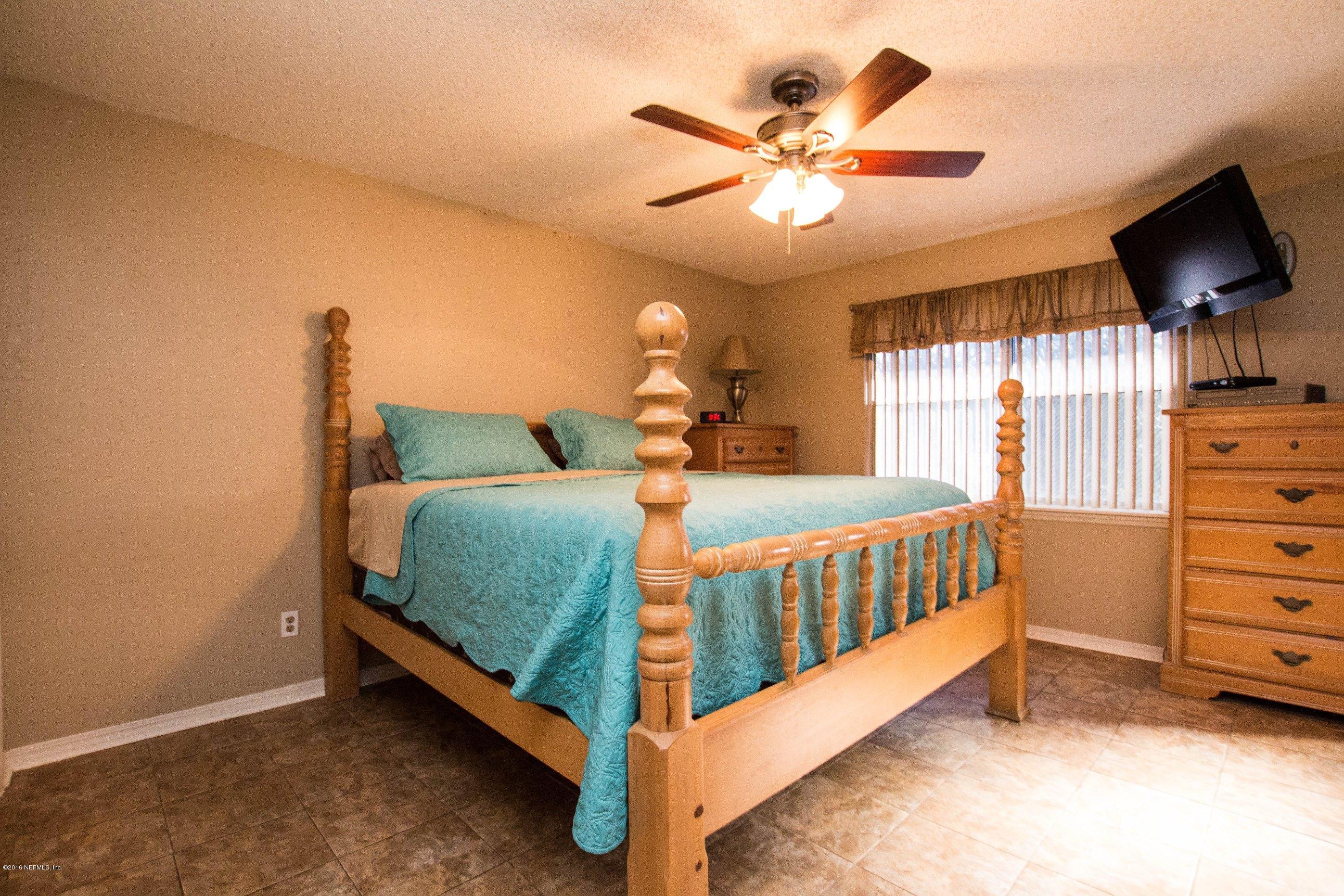 1609 Derringer Road Jacksonville, FL 32225 - Photo 20 of 33 a bedroom with a bed and a chandelier