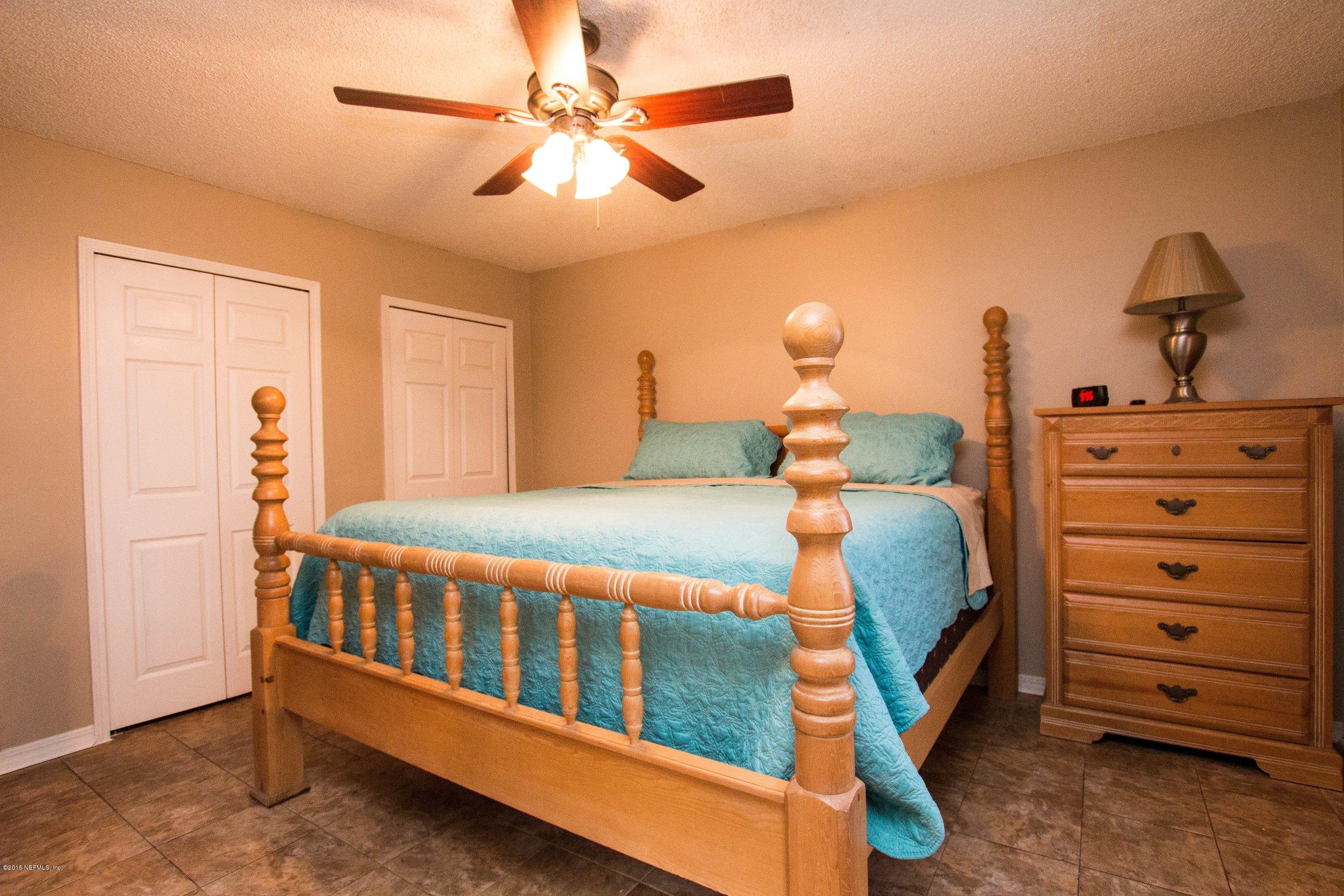 1609 Derringer Road Jacksonville, FL 32225 - Photo 21 of 33 a bedroom with a bed and a chandelier