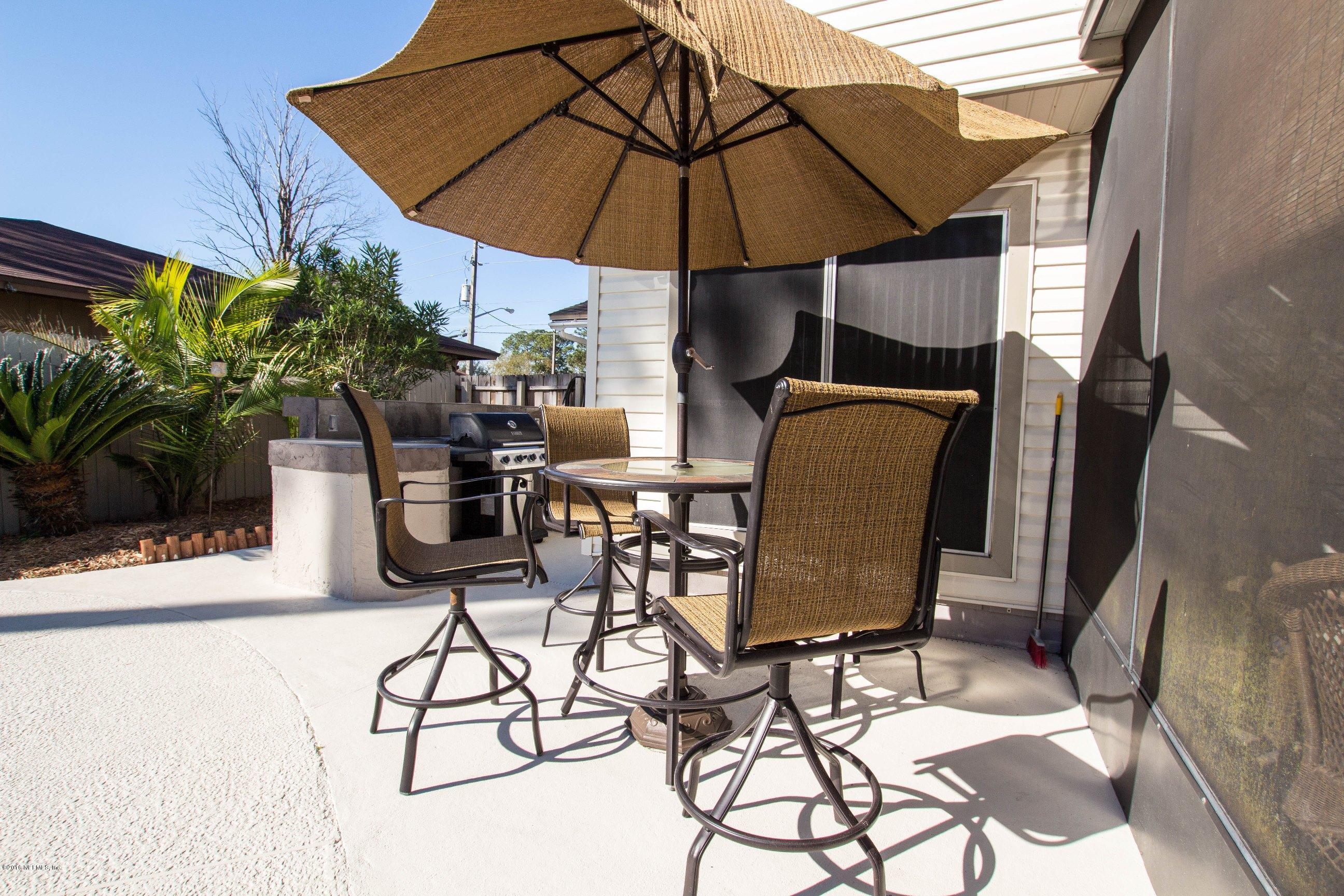 1609 Derringer Road Jacksonville, FL 32225 - Photo 30 of 33 a view of a patio with table and chairs under an umbrella