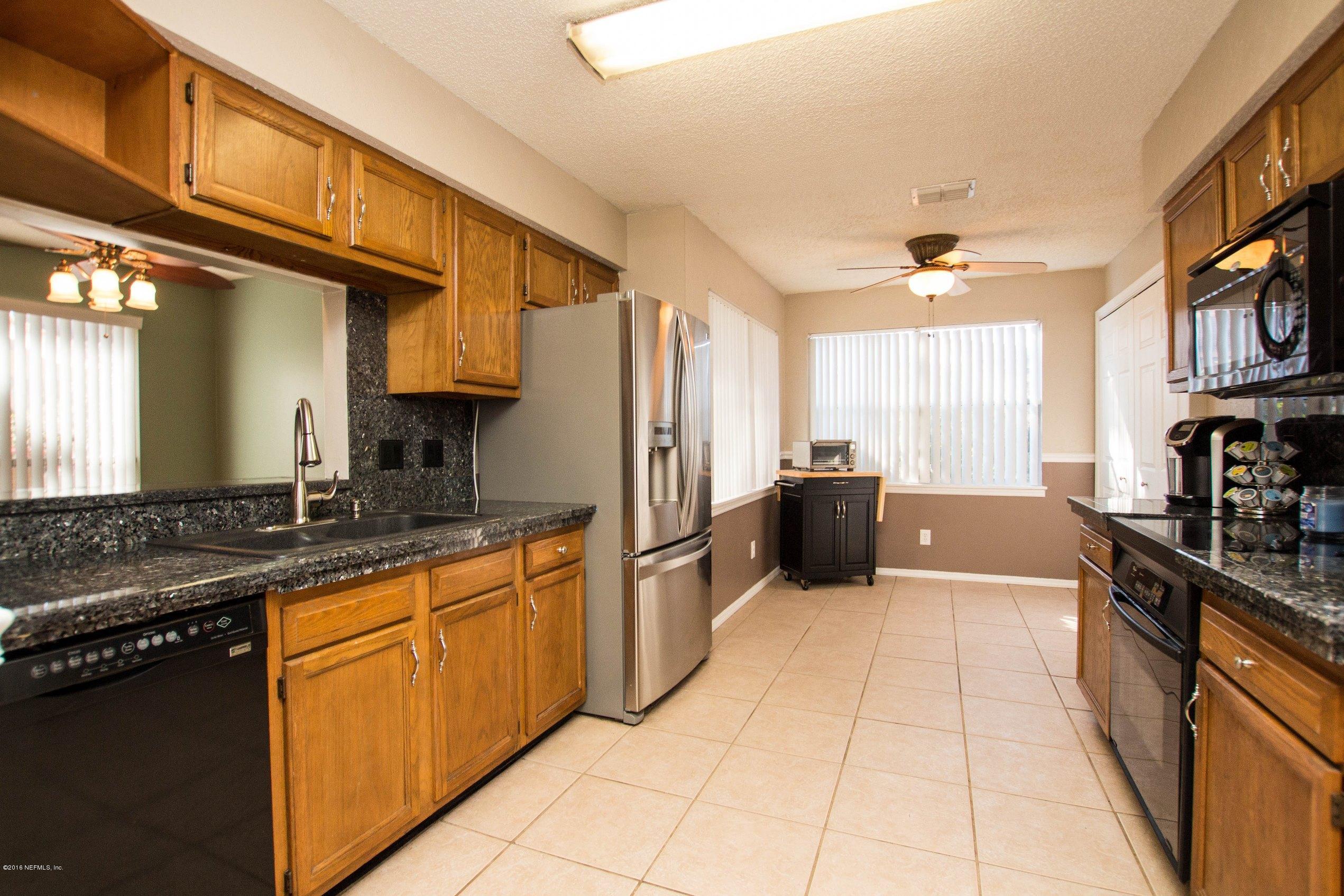 1609 Derringer Road Jacksonville, FL 32225 - Photo 4 of 33 a kitchen with stainless steel appliances granite countertop a sink and cabinets