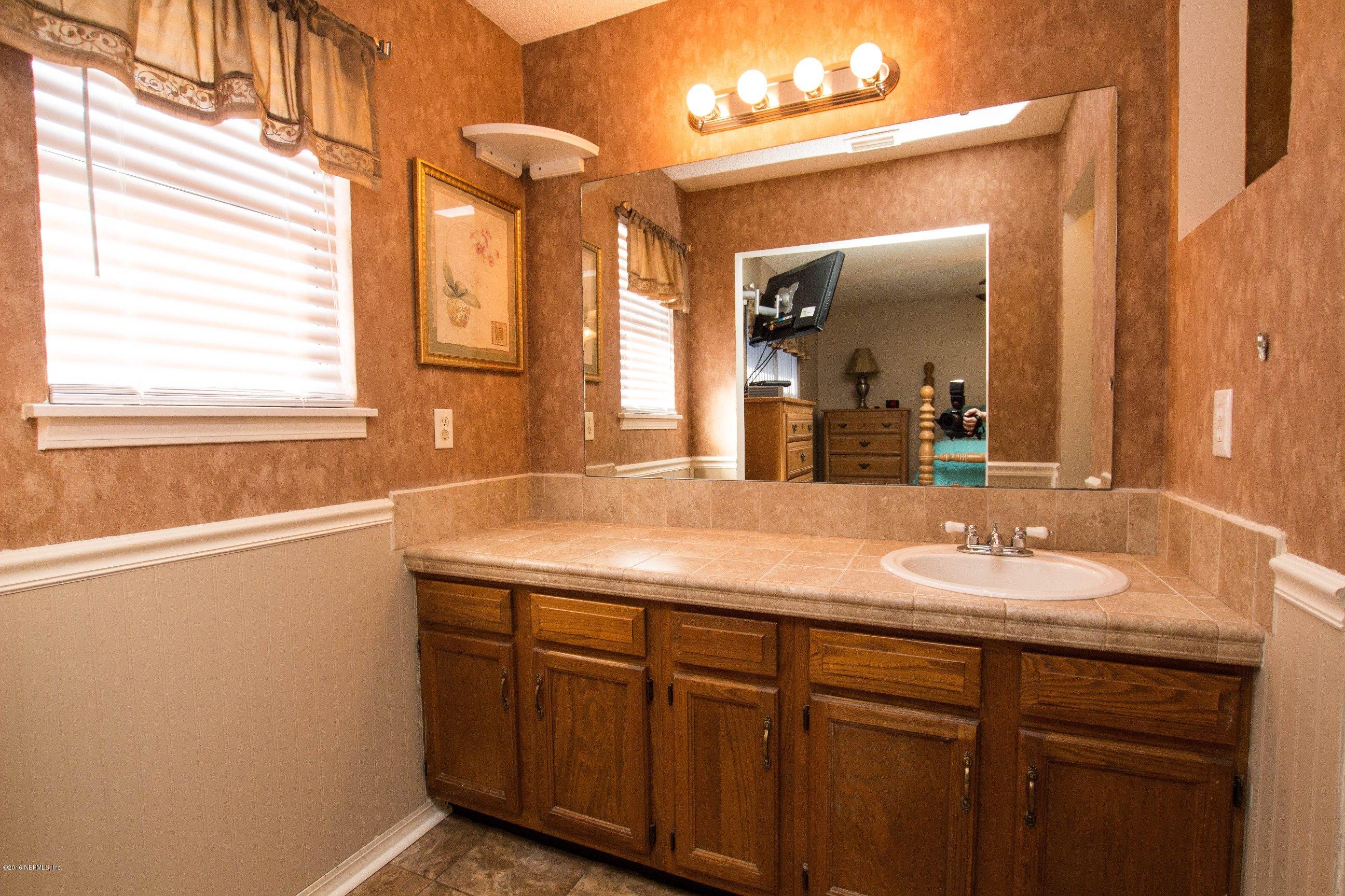 1609 Derringer Road Jacksonville, FL 32225 - Photo 5 of 33 a bathroom with a granite countertop sink and a mirror