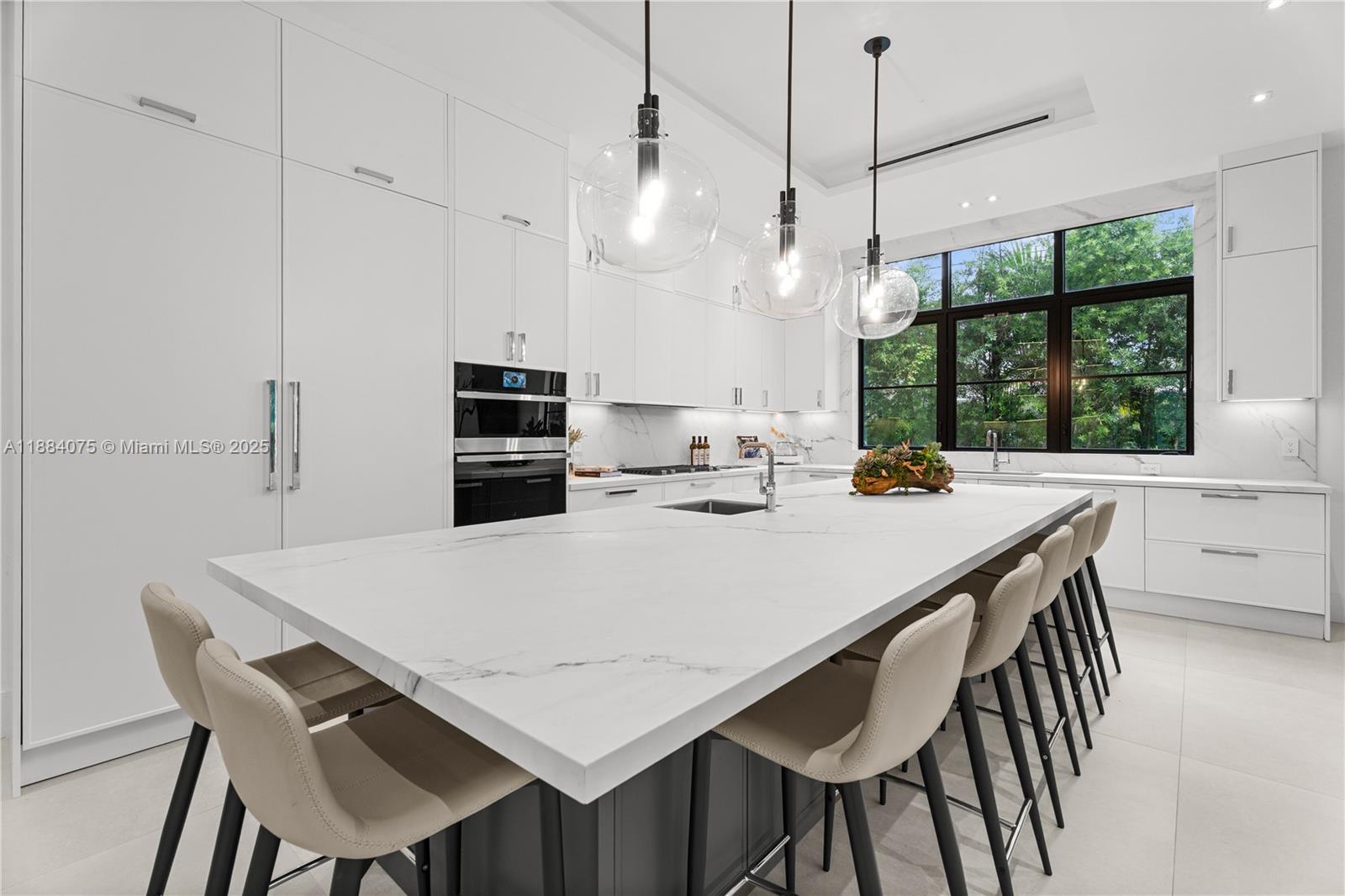 7001 Southwest 71st Avenue Miami, FL 33143 - Photo 34 of 50 a kitchen with a dining table chairs and white cabinets