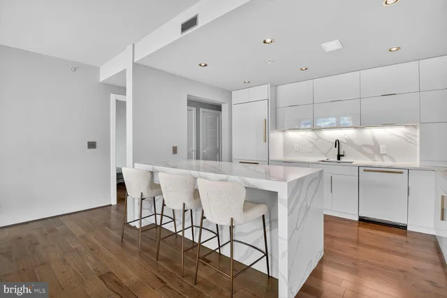 a kitchen with kitchen island white cabinets and stainless steel appliances
