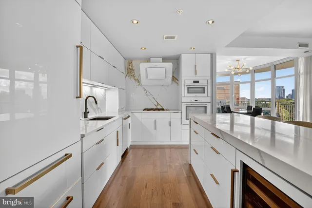 a large white kitchen with stainless steel appliances