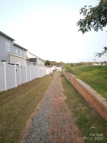 a view of a dry yard with wooden fence