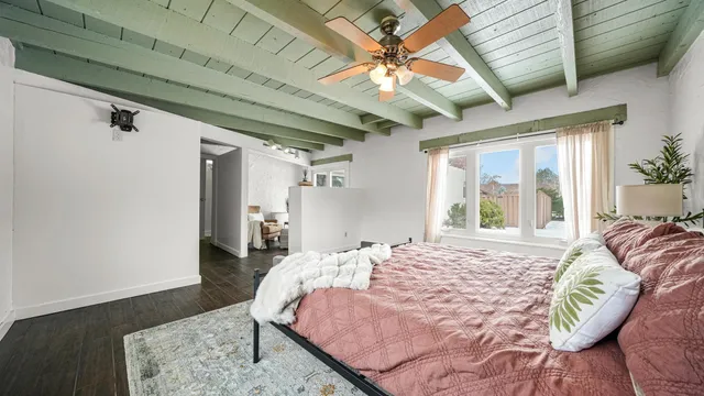 a bed sitting in a spacious bedroom next to a window