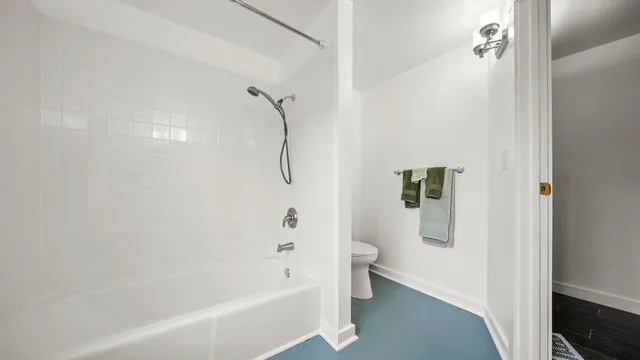 a bathroom with a bathtub a toilet and a shower