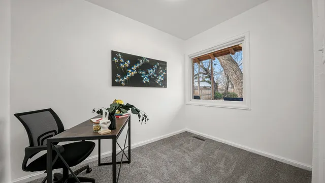 a view of a workspace with furniture and a window