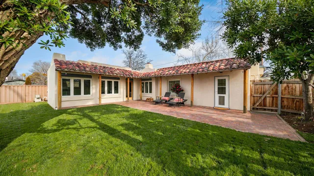 a view of a house with a yard patio and a table and chairs