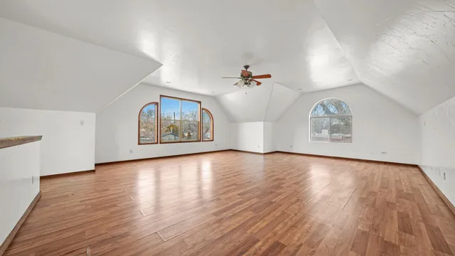 a view of an empty room with window and wooden floor
