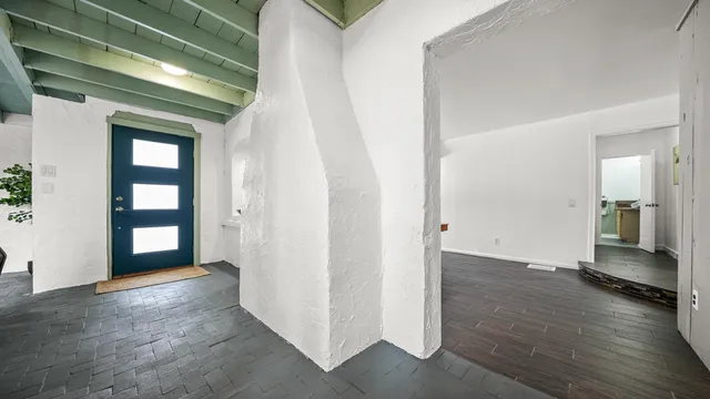 a view of a hallway with wooden floor and a living room
