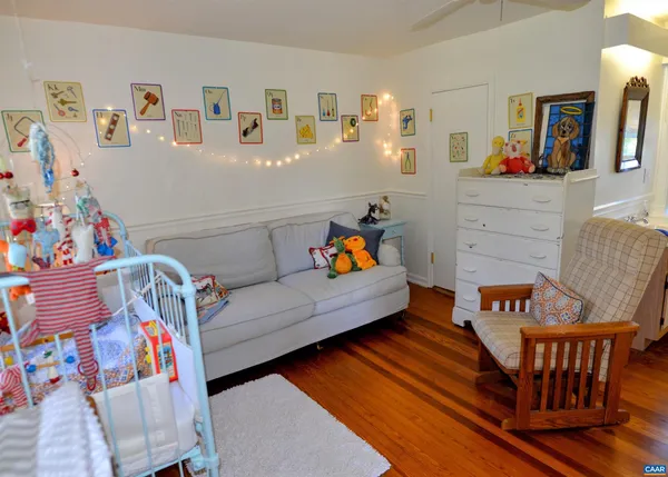 a living room with furniture and baby crib