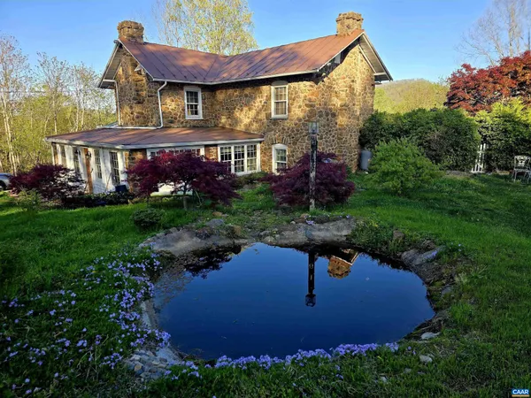 a view of a house with a yard and potted plants
