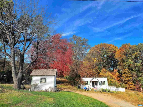 a front view of a house with a yard and tree