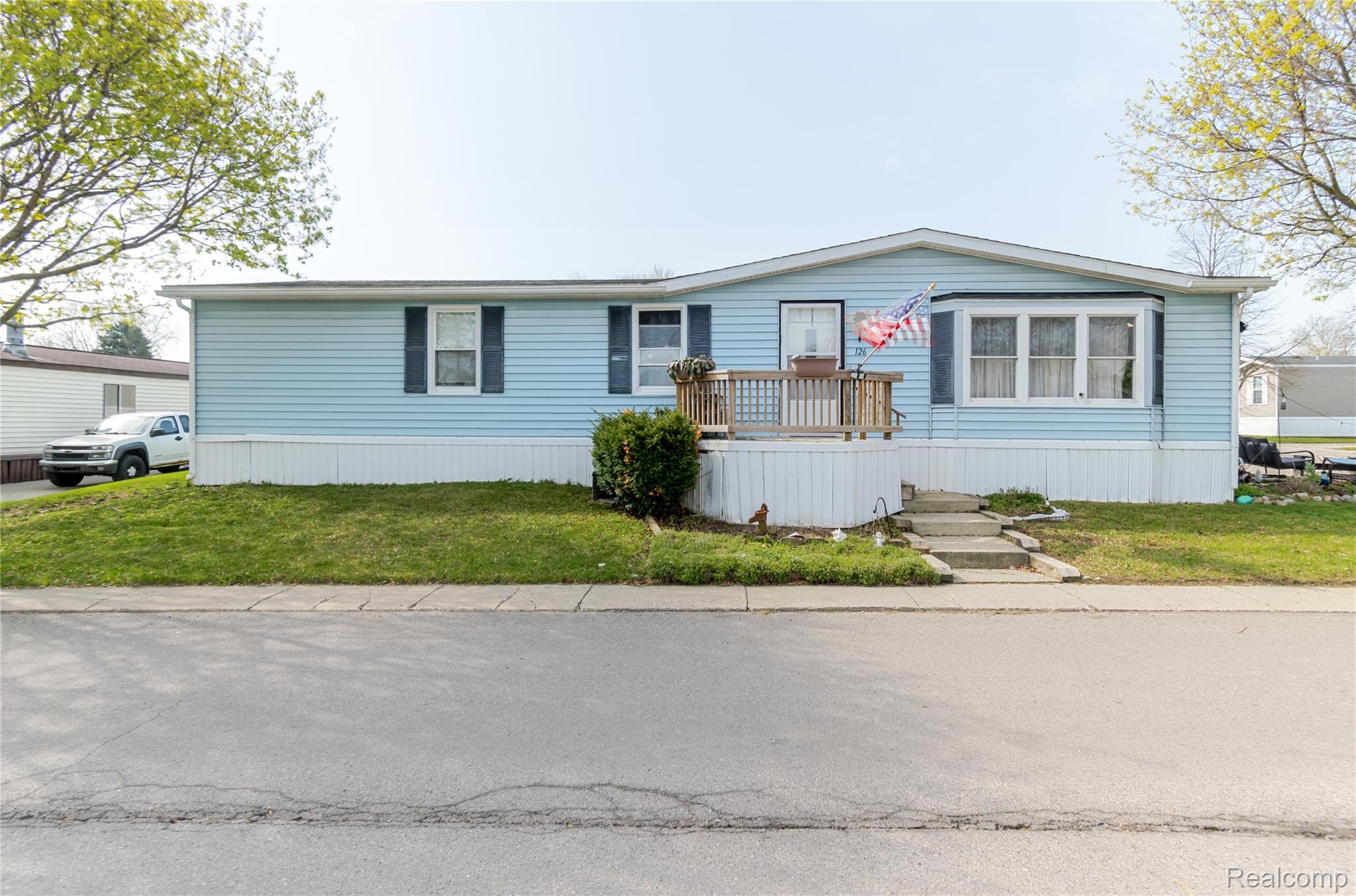 6655 Jackson Road, Unit 126 Ann Arbor, MI 48103 - Photo 1 of 36 Manufactured / mobile home featuring a front yard and a deck