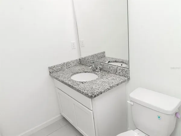 a bathroom with a granite countertop toilet a sink and bathtub