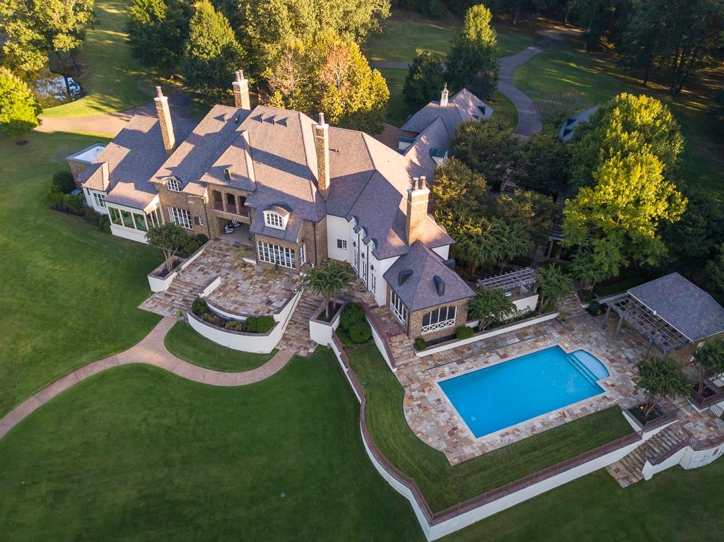 a aerial view of a house with swimming pool a yard and outdoor seating