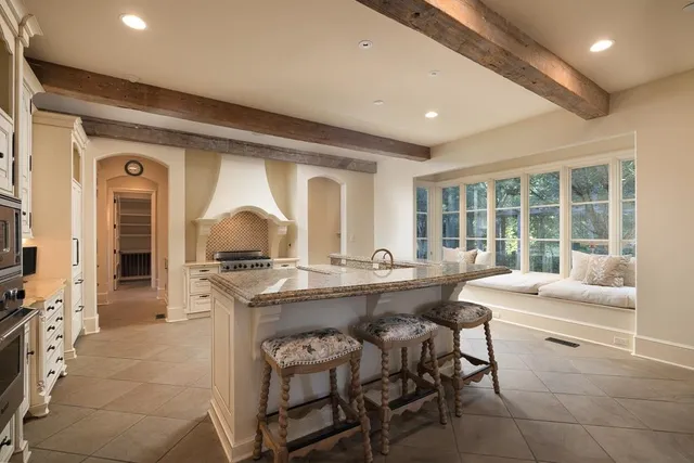 a dining hall with stainless steel appliances granite countertop a stove and a sink