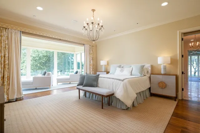 a spacious bedroom with a bed and a chandelier