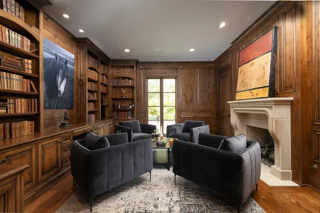 a living room with fireplace furniture and a large window