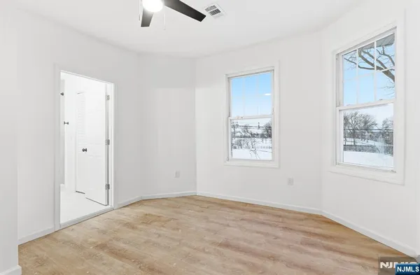 a view of a room with a stylish ceiling fan and entryway
