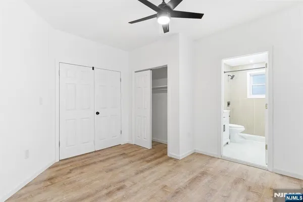 an empty room with a window and ceiling fan