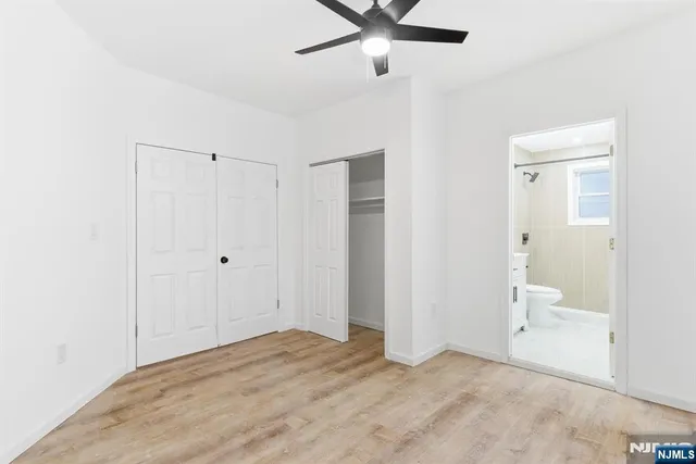 an empty room with a window and ceiling fan