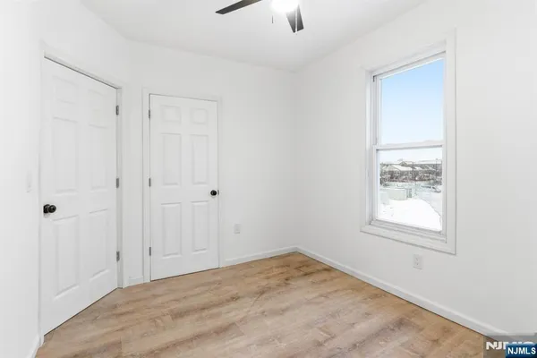 an empty room with windows and fan