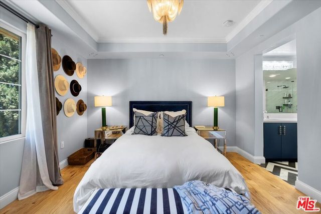 a bedroom with bed and a flat tv screen on dresser