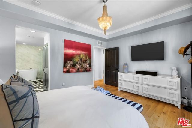 a bedroom with a bed and a chandelier