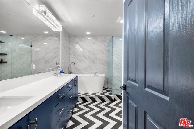 a spacious bathroom with a double vanity sink mirror and bathtub