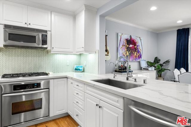 a view of kitchen island furniture a sink and a refrigerator