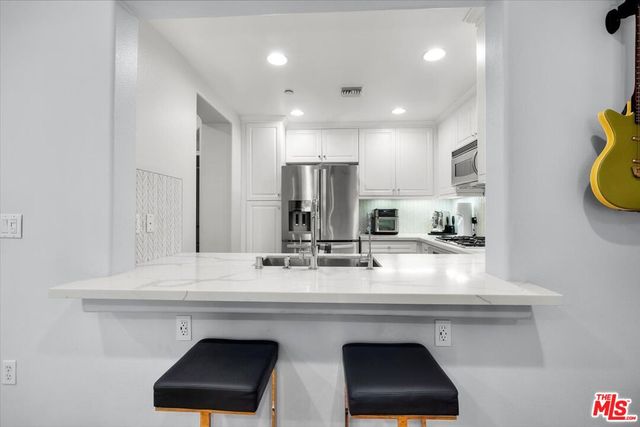 a view of a dining room with furniture a potted plant and wooden floor