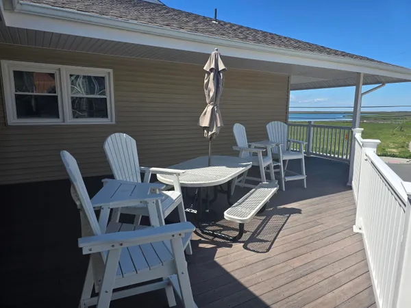 a view of a deck with table and chairs with wooden floor and fence
