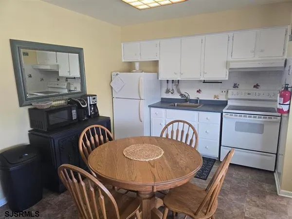 a kitchen with a sink a refrigerator and cabinets