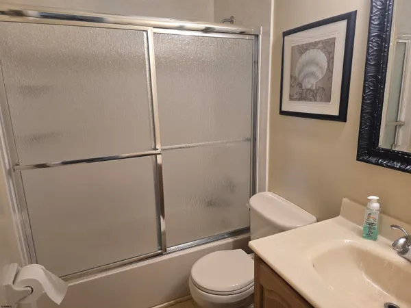 a bathroom with a shower toilet and sink