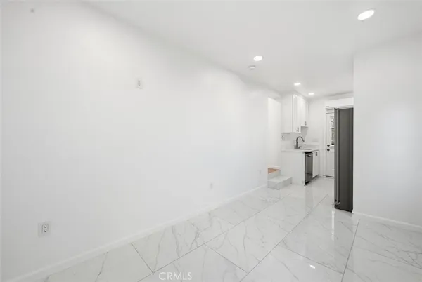 a view of a big room with a refrigerator and mirror