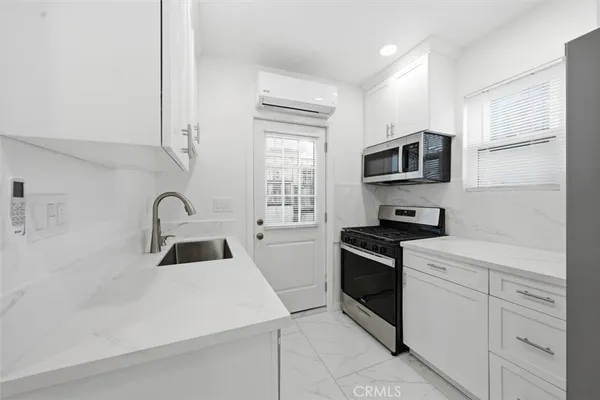 a kitchen with white cabinets and appliances