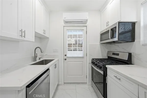 a kitchen with stainless steel appliances granite countertop a sink stove top oven and refrigerator