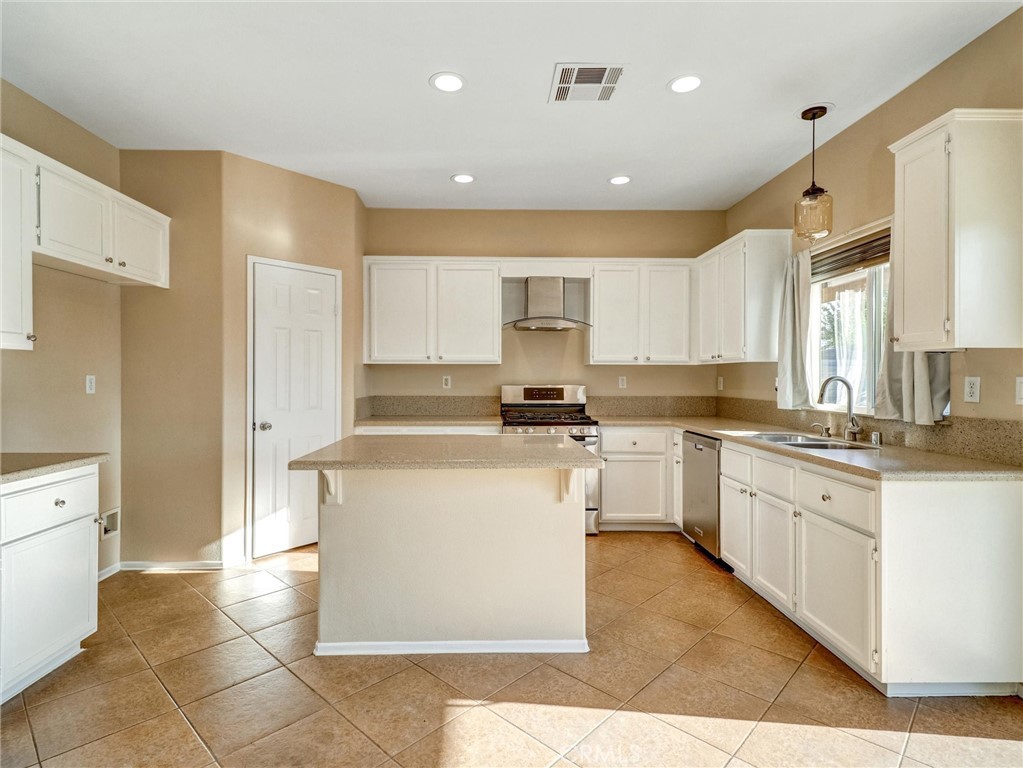 47718 Phoenix Street Indio, CA 92201 - Photo 21 of 54 a large kitchen with stainless steel appliances granite countertop a stove a sink a refrigerator and cabinets
