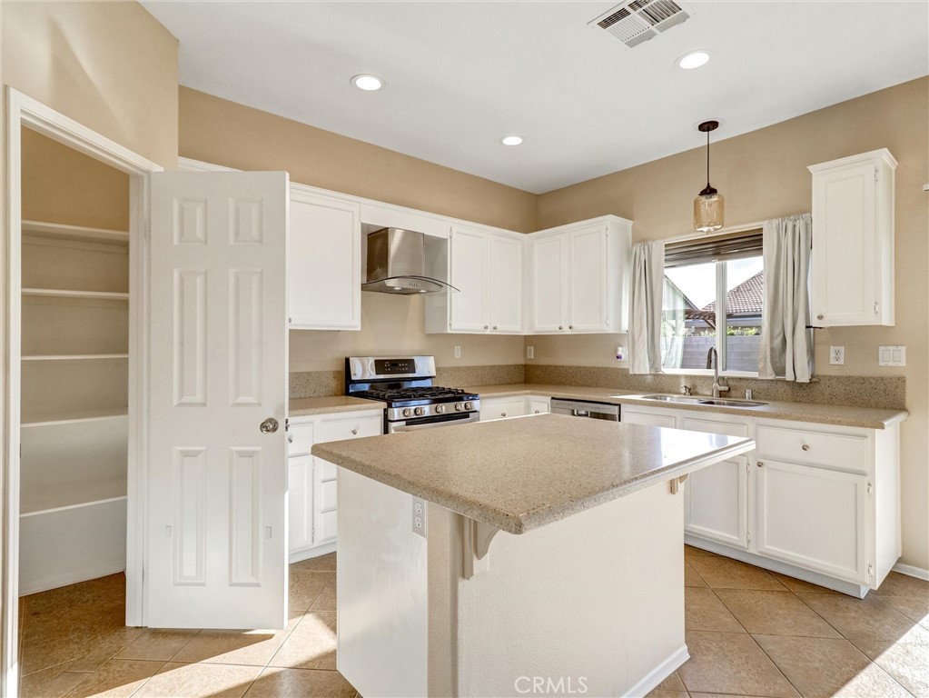 47718 Phoenix Street Indio, CA 92201 - Photo 22 of 54 a kitchen with granite countertop a sink stainless steel appliances and white cabinets